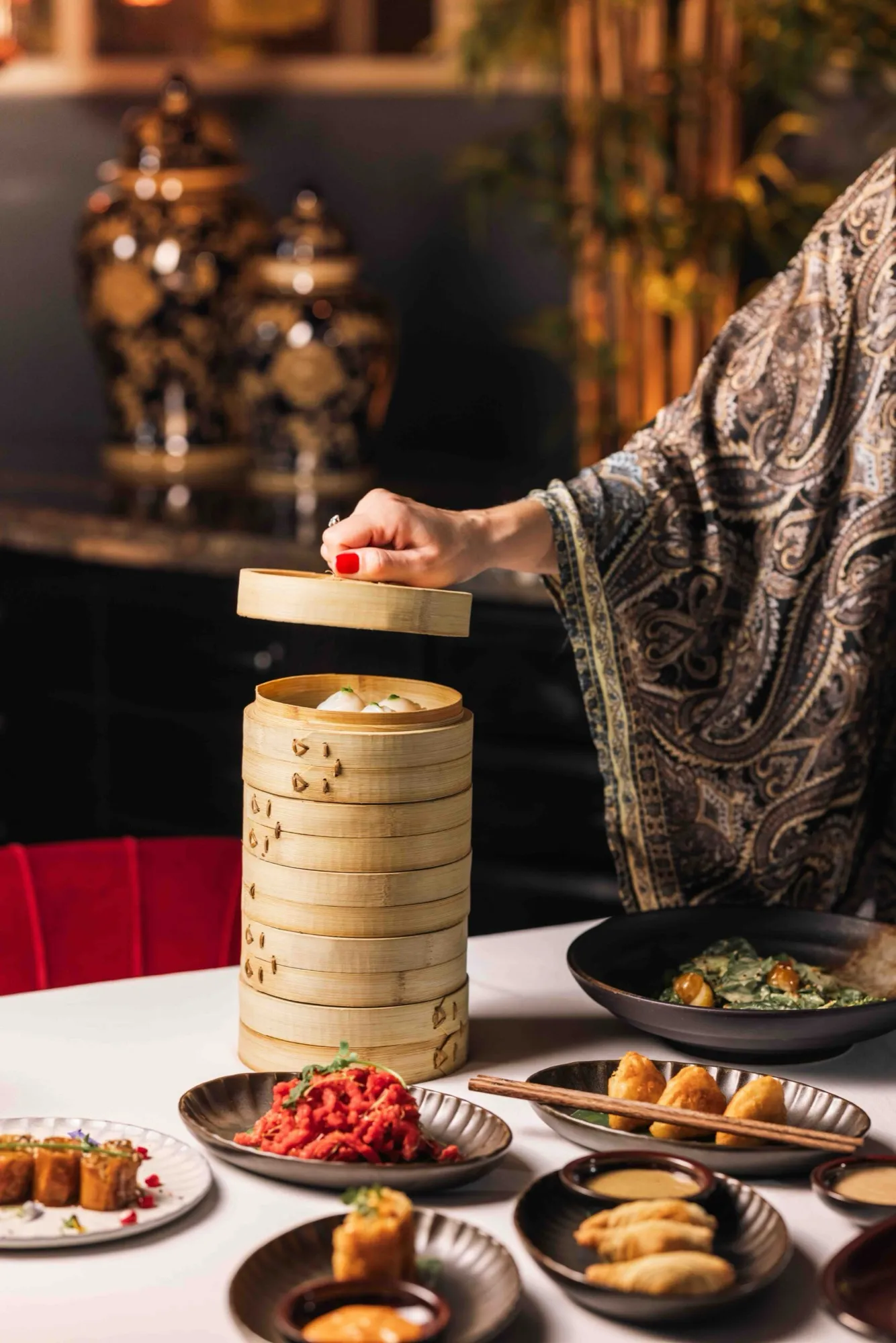 Dim sum steamer lifted by a guest at the table