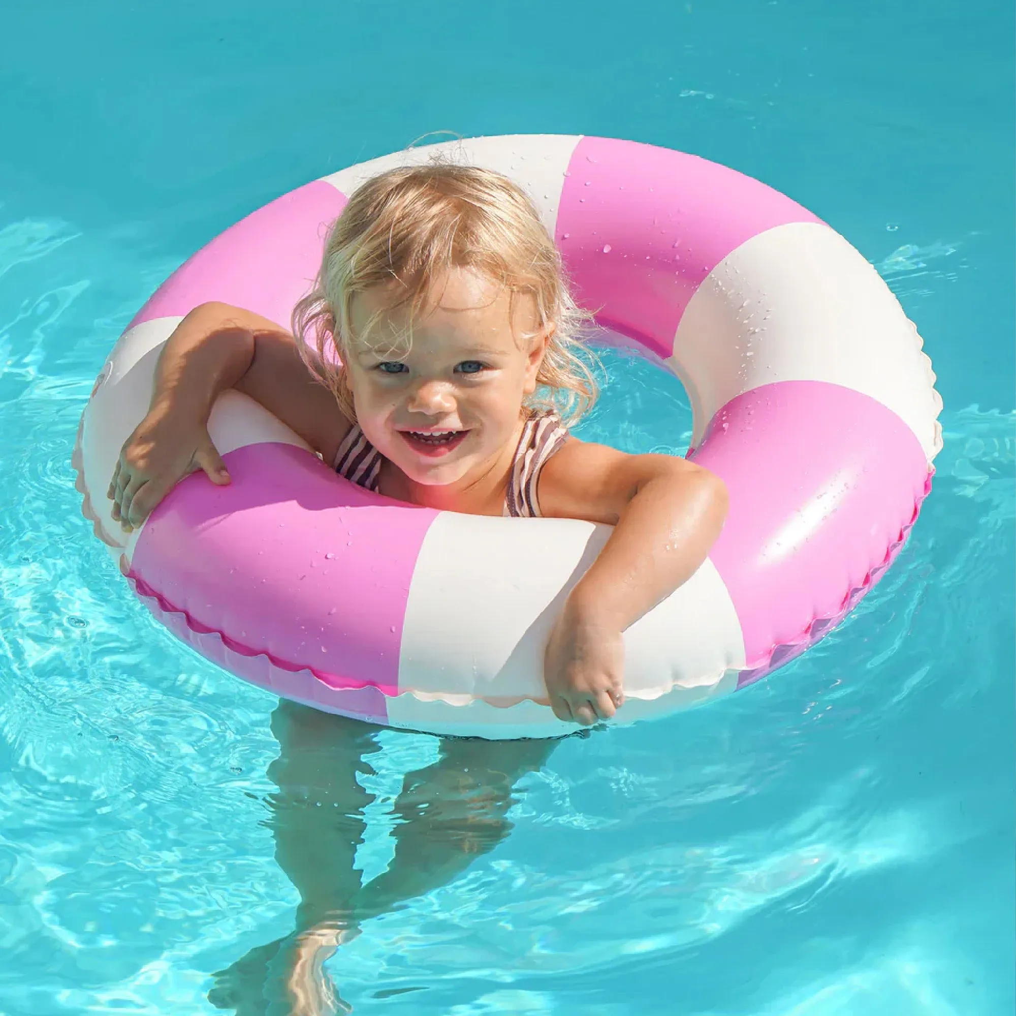 Child in a pink float in a pool