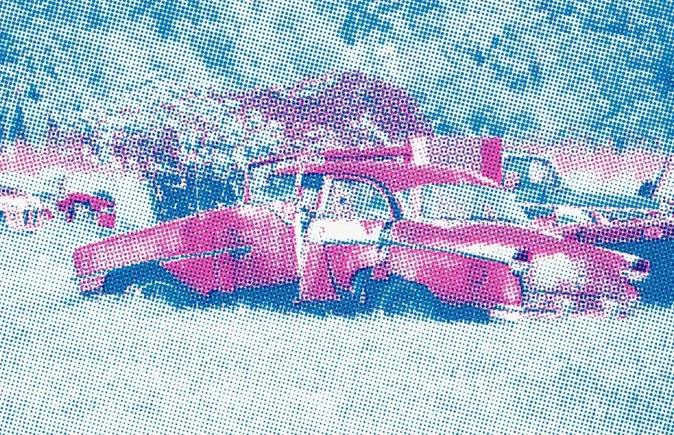 Halftone photo of a wrecked red car among trees