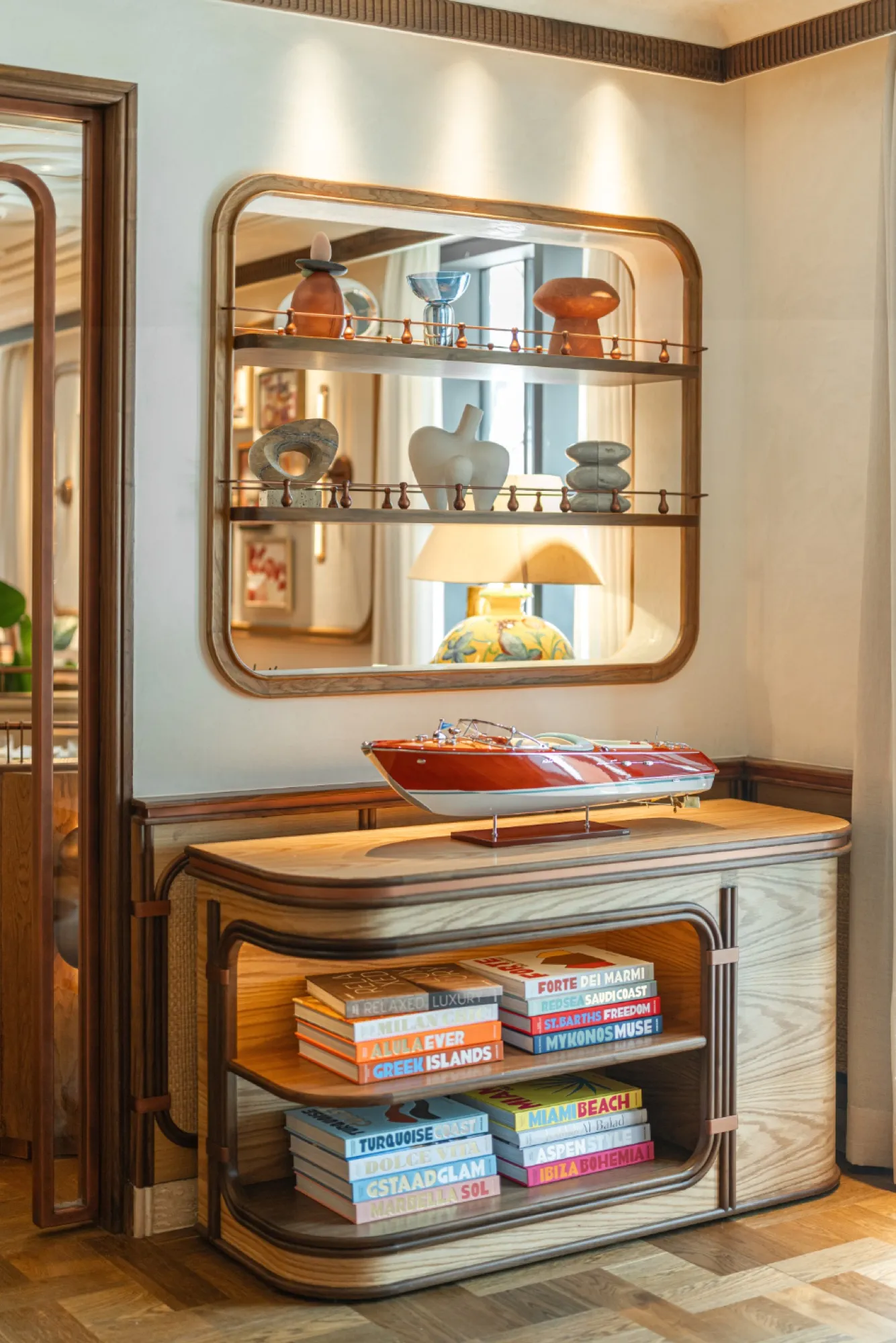 Mirror, lamp and model boat on a sideboard