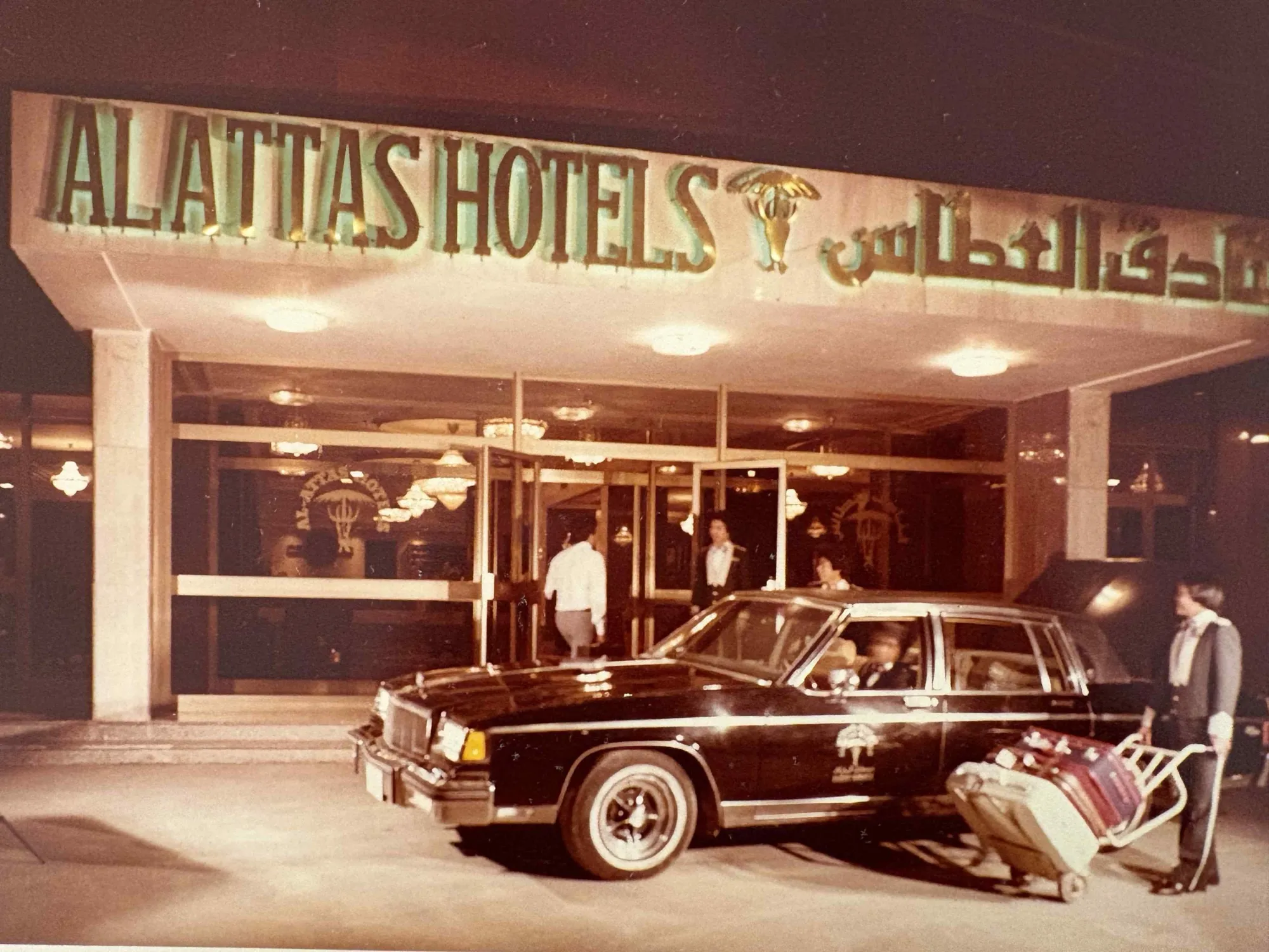 Vintage photograph of a hotel entrance with a classic car